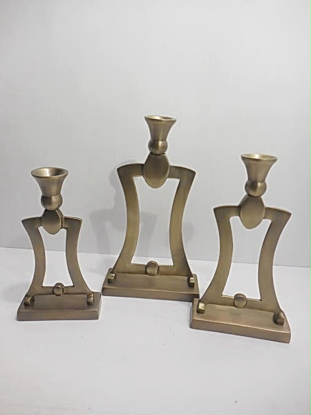 Three sculptural metal taper candle holders